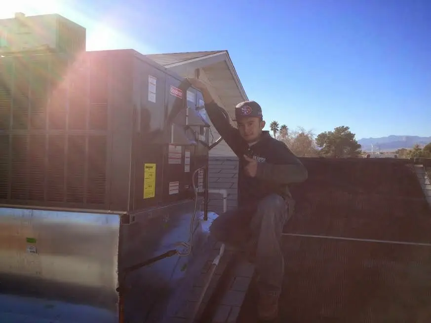HVAC technician performing Boiler Repair on a rooftop unit in Madisonville